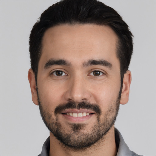 Joyful white young-adult male with short  black hair and brown eyes