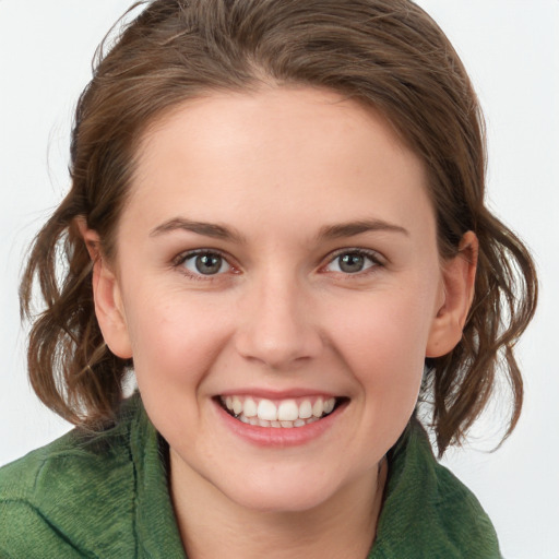 Joyful white young-adult female with medium  brown hair and green eyes