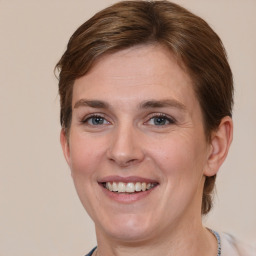 Joyful white adult female with medium  brown hair and grey eyes