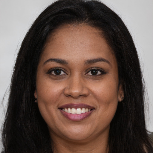 Joyful black young-adult female with long  brown hair and brown eyes