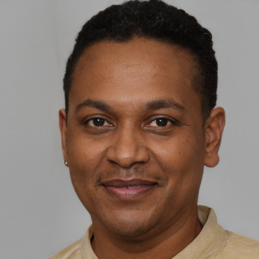 Joyful black adult male with short  brown hair and brown eyes