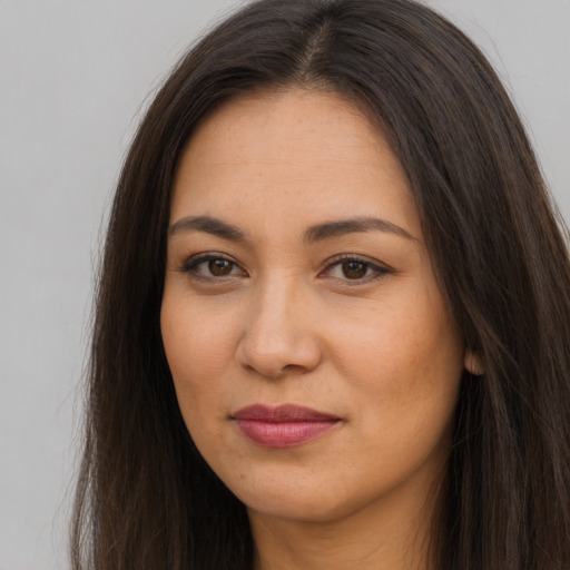 Joyful latino young-adult female with long  brown hair and brown eyes