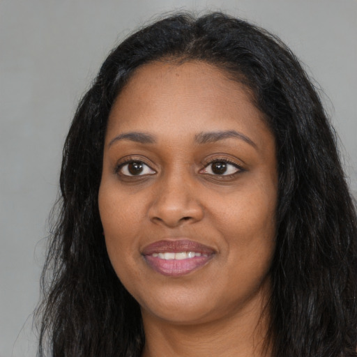 Joyful black young-adult female with long  black hair and brown eyes