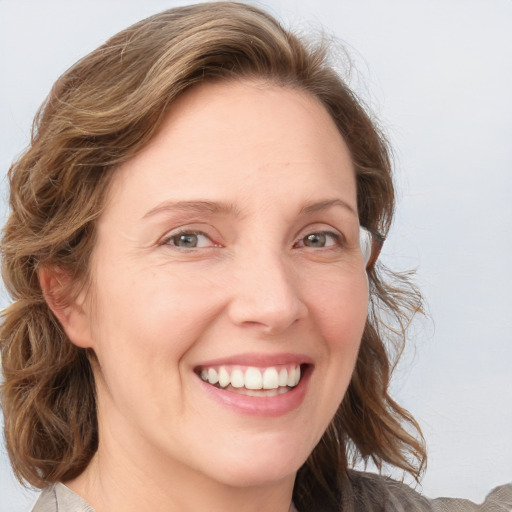 Joyful white young-adult female with medium  brown hair and blue eyes