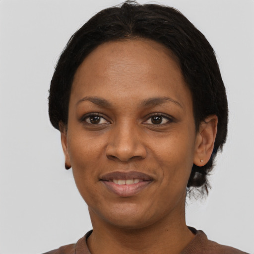 Joyful black young-adult female with short  black hair and brown eyes
