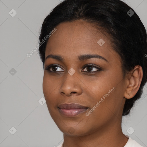 Joyful black young-adult female with short  black hair and brown eyes