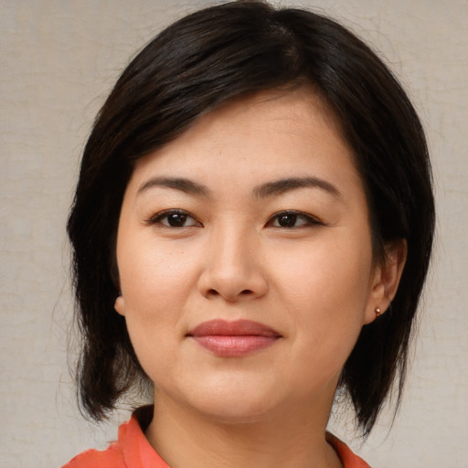 Joyful asian young-adult female with medium  brown hair and brown eyes
