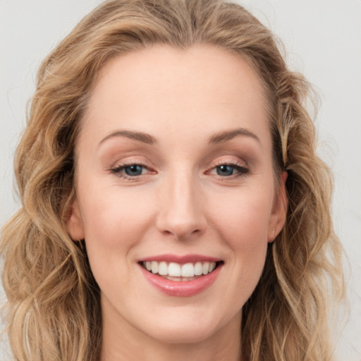 Joyful white young-adult female with long  brown hair and blue eyes