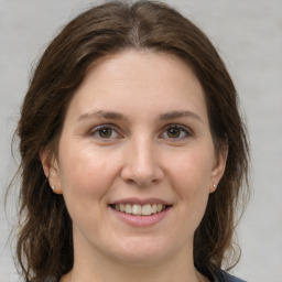 Joyful white adult female with medium  brown hair and grey eyes