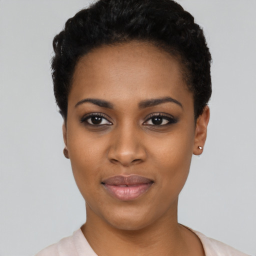 Joyful black young-adult female with short  black hair and brown eyes