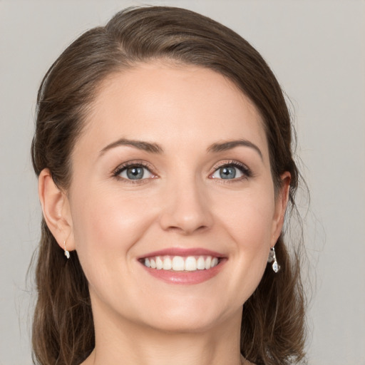 Joyful white young-adult female with medium  brown hair and grey eyes