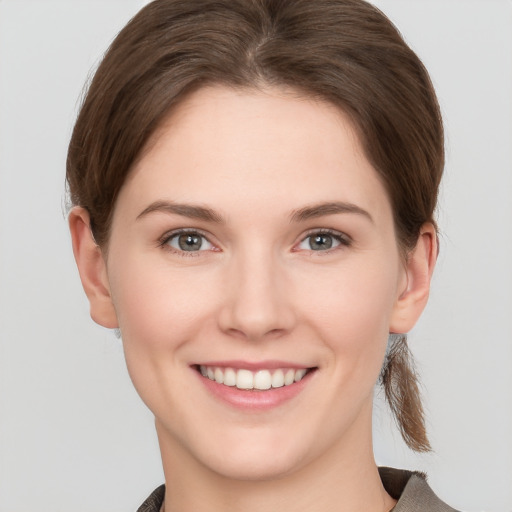 Joyful white young-adult female with short  brown hair and grey eyes