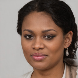 Joyful black young-adult female with long  brown hair and brown eyes