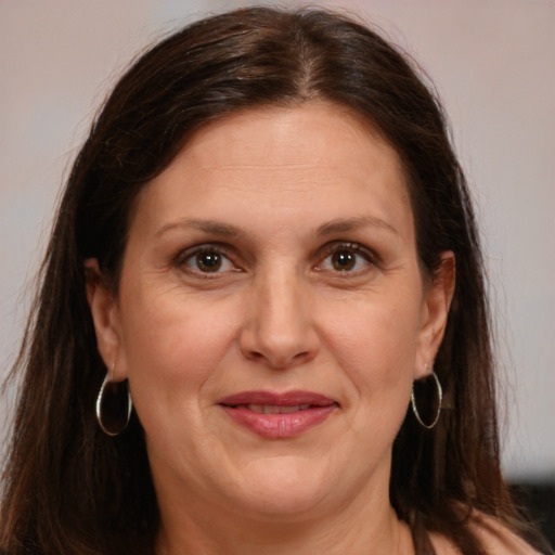 Joyful white adult female with long  brown hair and brown eyes