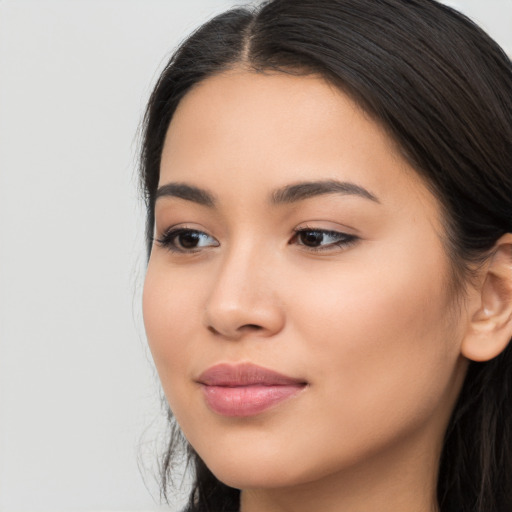 Joyful latino young-adult female with long  brown hair and brown eyes