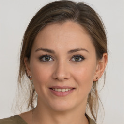 Joyful white young-adult female with medium  brown hair and grey eyes