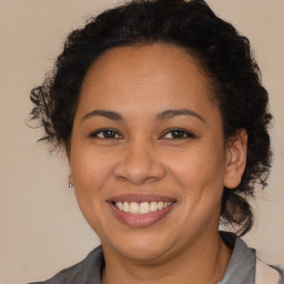 Joyful latino adult female with medium  brown hair and brown eyes