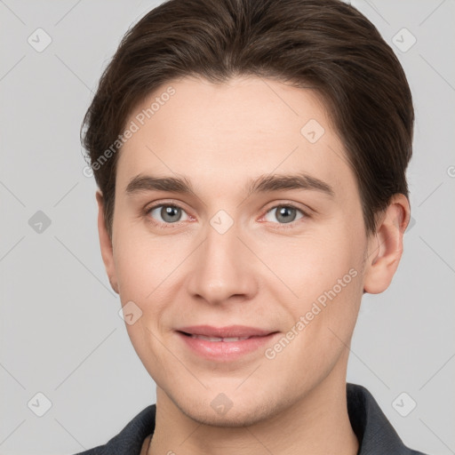 Joyful white young-adult male with short  brown hair and grey eyes