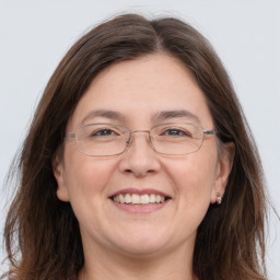 Joyful white adult female with long  brown hair and grey eyes