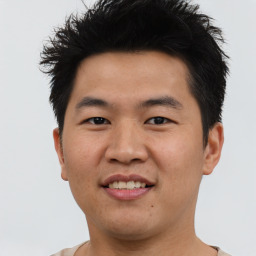 Joyful asian young-adult male with short  brown hair and brown eyes