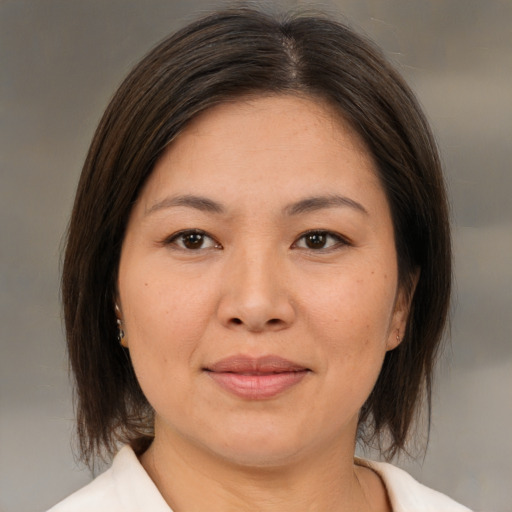 Joyful asian adult female with medium  brown hair and brown eyes