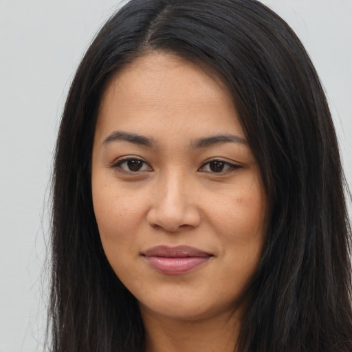 Joyful latino young-adult female with long  brown hair and brown eyes