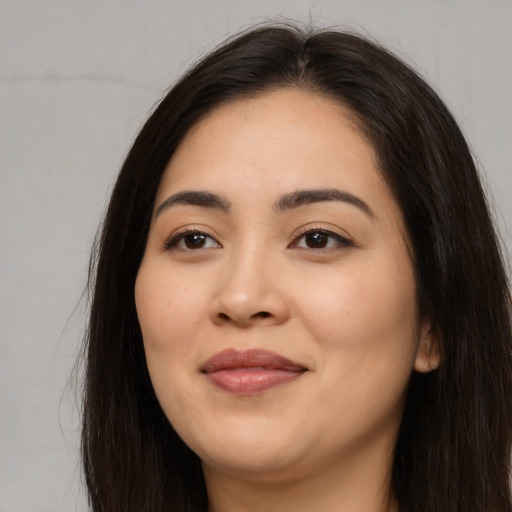 Joyful asian young-adult female with long  brown hair and brown eyes