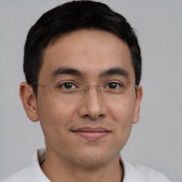 Joyful latino young-adult male with short  brown hair and brown eyes