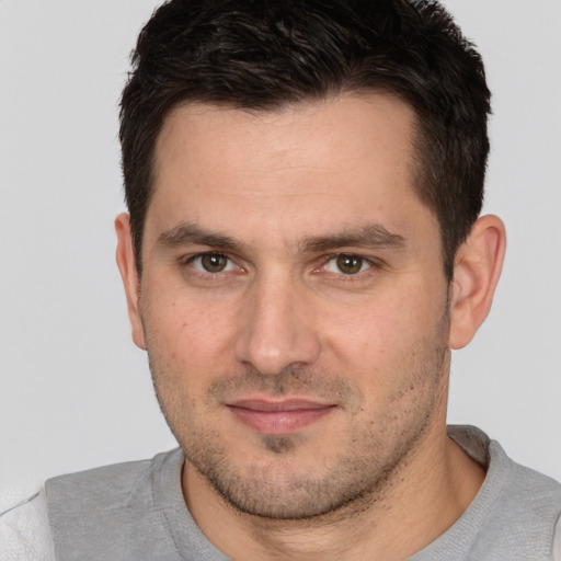 Joyful white young-adult male with short  brown hair and brown eyes