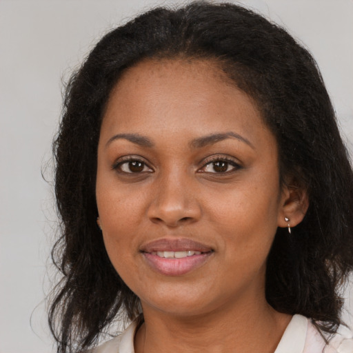 Joyful black adult female with long  brown hair and brown eyes