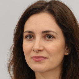 Joyful white adult female with long  brown hair and brown eyes