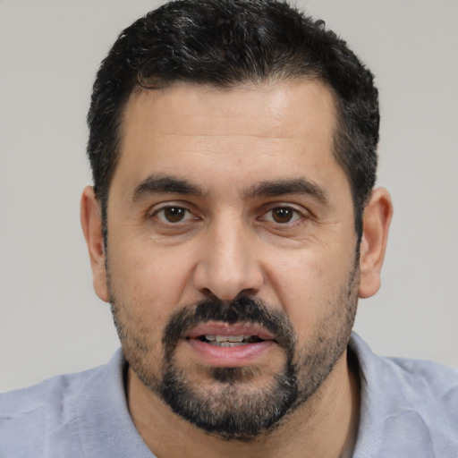 Joyful white adult male with short  black hair and brown eyes