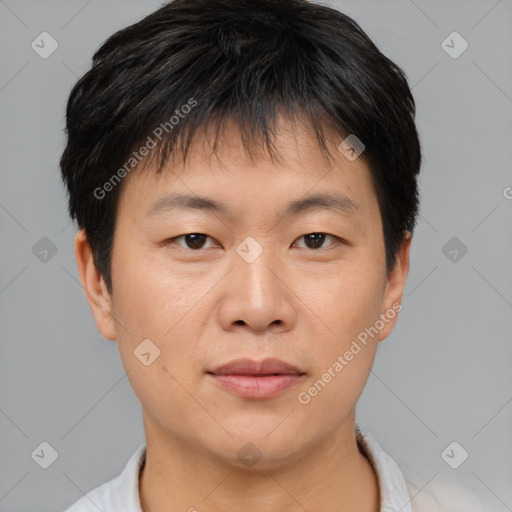 Joyful asian young-adult male with short  brown hair and brown eyes