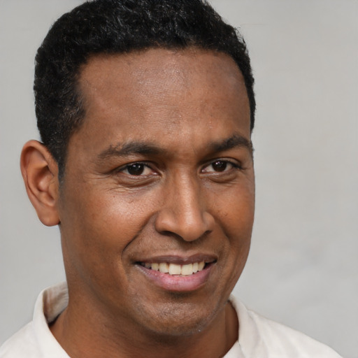 Joyful latino adult male with short  brown hair and brown eyes