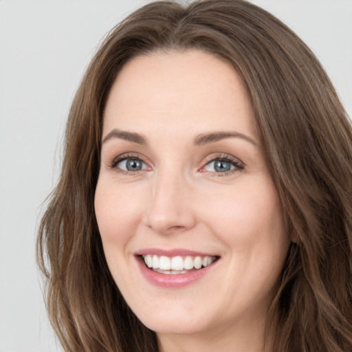 Joyful white young-adult female with long  brown hair and green eyes