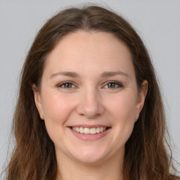 Joyful white young-adult female with long  brown hair and grey eyes