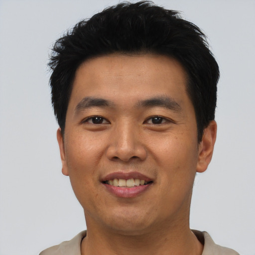 Joyful asian young-adult male with short  black hair and brown eyes