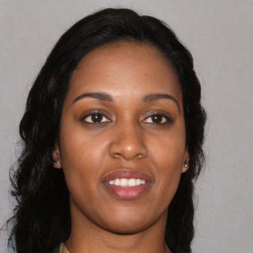 Joyful black young-adult female with long  black hair and brown eyes