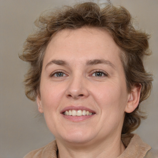 Joyful white adult female with medium  brown hair and grey eyes