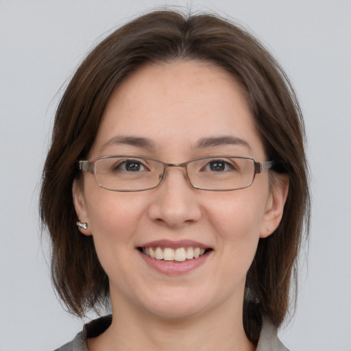 Joyful white young-adult female with medium  brown hair and grey eyes