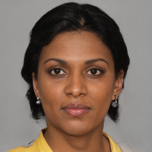 Joyful black young-adult female with medium  brown hair and brown eyes