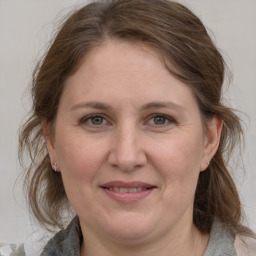 Joyful white adult female with medium  brown hair and grey eyes