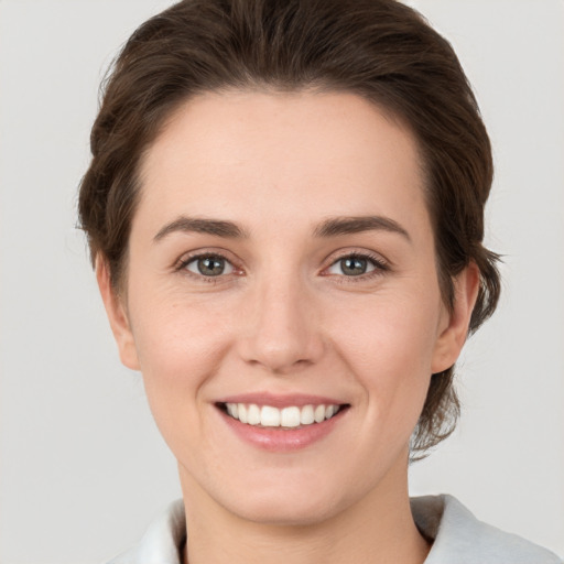 Joyful white young-adult female with medium  brown hair and grey eyes