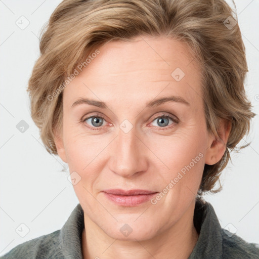 Joyful white adult female with medium  brown hair and blue eyes