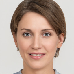 Joyful white young-adult female with medium  brown hair and grey eyes