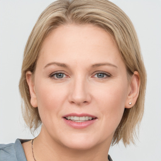 Joyful white adult female with medium  brown hair and blue eyes