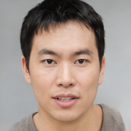 Joyful asian young-adult male with short  brown hair and brown eyes