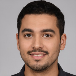 Joyful white young-adult male with short  black hair and brown eyes