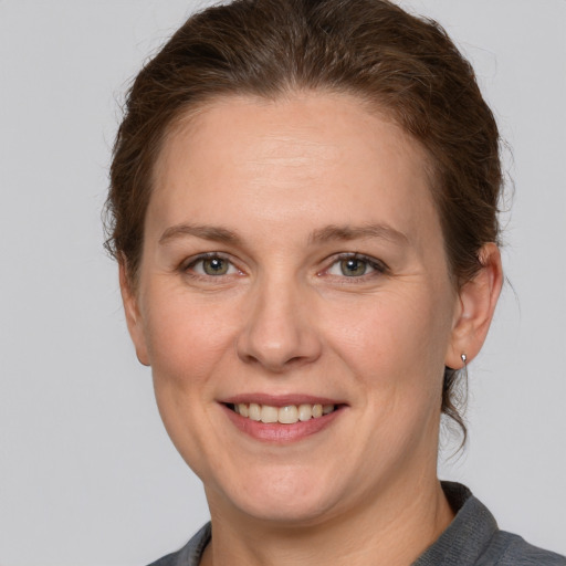 Joyful white adult female with short  brown hair and grey eyes