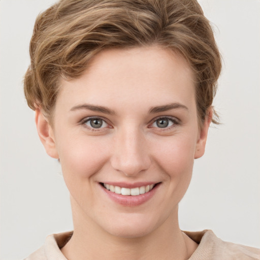 Joyful white young-adult female with short  brown hair and grey eyes